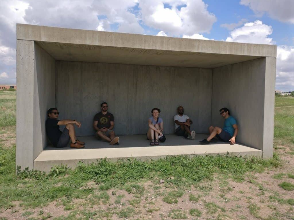 Produktworks team sitting inside a concrete art installation at Chinatti Marfa